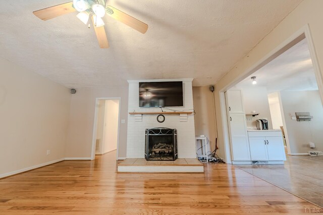 1553 Old Stage Rd, Amherst, VA 24521 - unfurnished living room with a textured ceiling, wood finished floors, a brick fireplace, and a ceiling fan