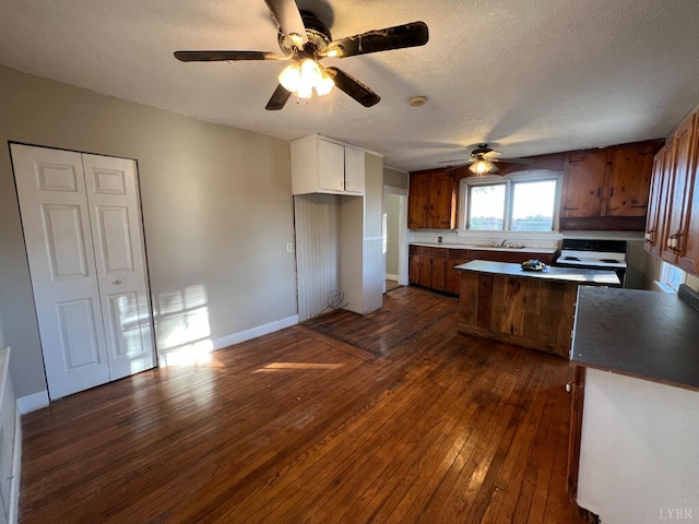 1358 S Coolwell Rd, Madison Heights, VA 24572 - kitchen with dark wood-style floors, a sink, ceiling fan, a textured ceiling, and brown cabinets