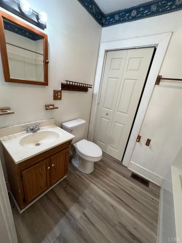 1358 S Coolwell Rd, Madison Heights, VA 24572 - full bathroom with vanity, toilet, wood finished floors, and visible vents