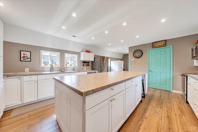 3554 Leffel Rd, Roanoke, VA 24018 - kitchen featuring a kitchen island, stainless steel appliances, a sink, light wood-style floors, and recessed lighting