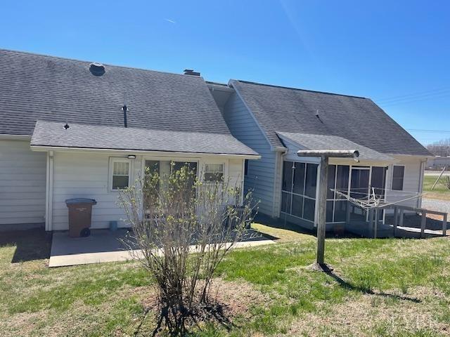 1534 Main St, Altavista, VA 24517 - back of property with a sunroom, a patio, a yard, and a shingled roof