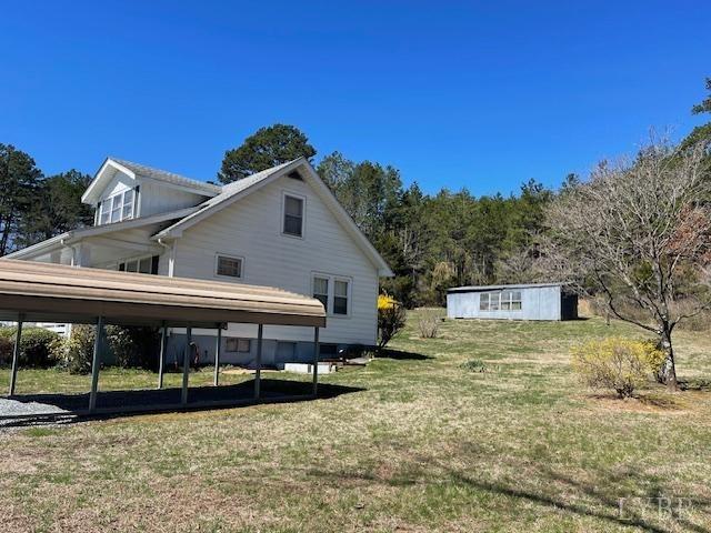 1534 Main St, Altavista, VA 24517 - view of home's exterior with a carport, a yard, and an outdoor structure