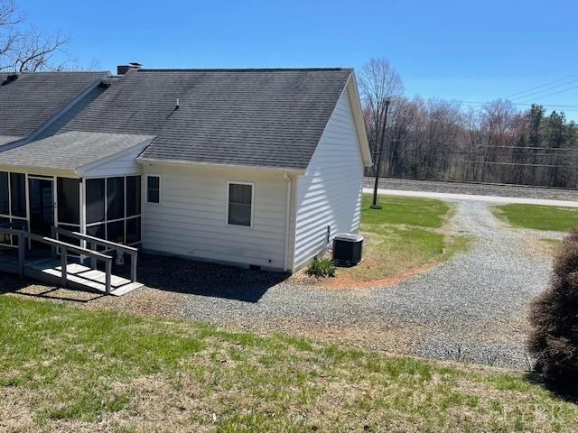 1534 Main St, Altavista, VA 24517 - back of house with roof with shingles, a sunroom, and central air condition unit