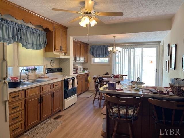 1534 Main St, Altavista, VA 24517 - kitchen with brown cabinetry, white appliances, a textured ceiling, and a sink