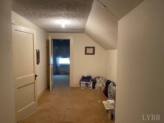 1534 Main St, Altavista, VA 24517 - hall featuring a textured ceiling, lofted ceiling, and carpet