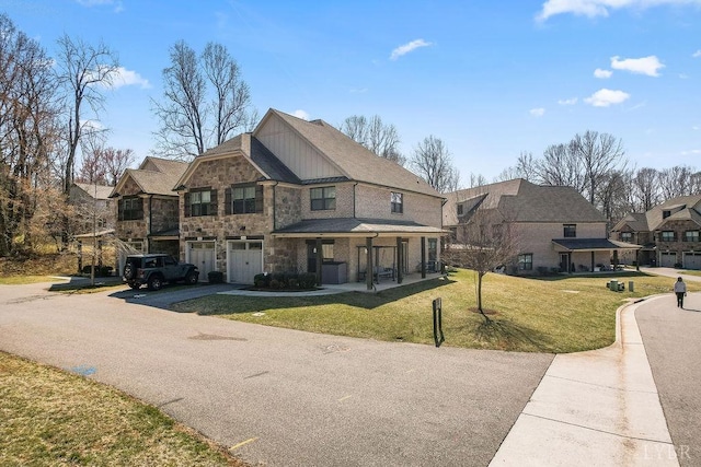 1055 Tori Ct, Forest, VA 24551 - view of front of property featuring driveway, a garage, a front yard, board and batten siding, and stone siding