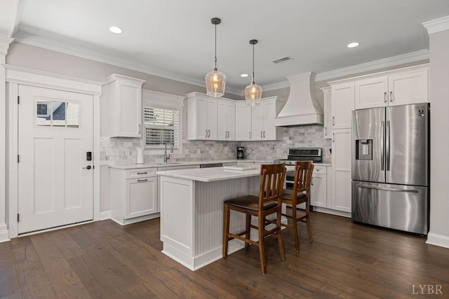 1055 Tori Ct, Forest, VA 24551 - kitchen featuring appliances with stainless steel finishes, custom exhaust hood, a sink, white cabinetry, and ornamental molding