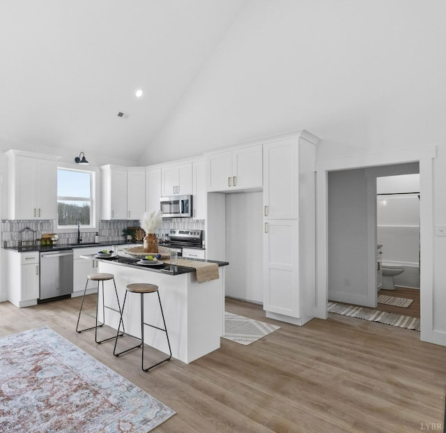 2116 Lime Plant Rd, Appomattox, VA 24522 - kitchen featuring stainless steel appliances, white cabinetry, high vaulted ceiling, backsplash, and dark countertops