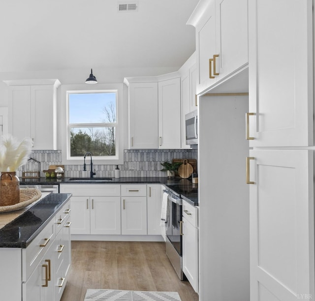 2116 Lime Plant Rd, Appomattox, VA 24522 - kitchen featuring stainless steel appliances, white cabinetry, tasteful backsplash, light wood-type flooring, and dark stone countertops