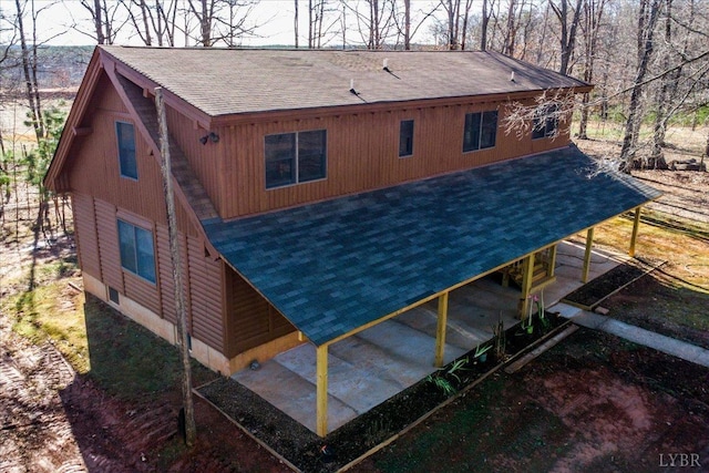 back of house with a shingled roof