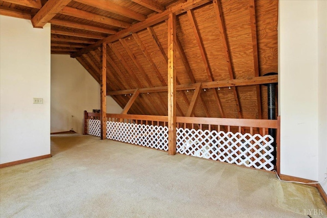 interior space featuring carpet flooring, lofted ceiling with beams, and baseboards