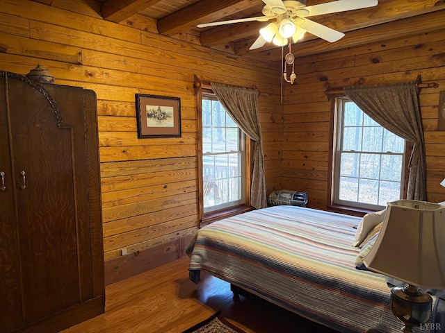 1228 Rosser Mill Rd, Pamplin, VA 23958 - bedroom with beamed ceiling, multiple windows, wooden walls, wood finished floors, and a ceiling fan
