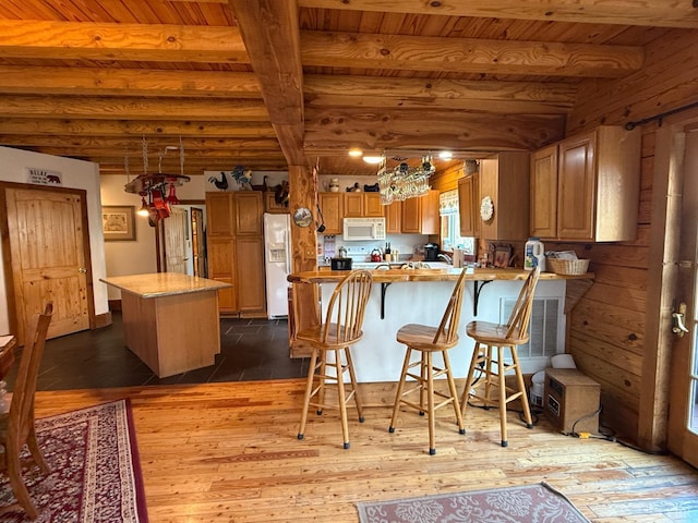 1228 Rosser Mill Rd, Pamplin, VA 23958 - kitchen with white appliances, a wood ceiling with exposed beams, dark wood-style flooring, brown cabinetry, and a peninsula