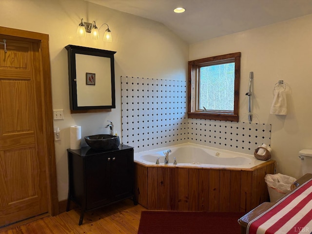 1228 Rosser Mill Rd, Pamplin, VA 23958 - bathroom featuring wood finished floors, a garden tub, vanity, and vaulted ceiling