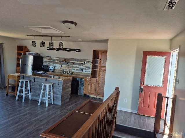 759 Grants Hollow Rd, Monroe, VA 24574 - interior space featuring dark wood-style flooring, a kitchen breakfast bar, stainless steel appliances, a kitchen island, and visible vents