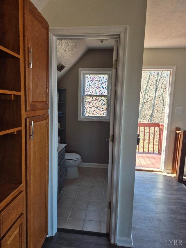 759 Grants Hollow Rd, Monroe, VA 24574 - bathroom with a textured ceiling, visible vents, baseboards, toilet, and lofted ceiling