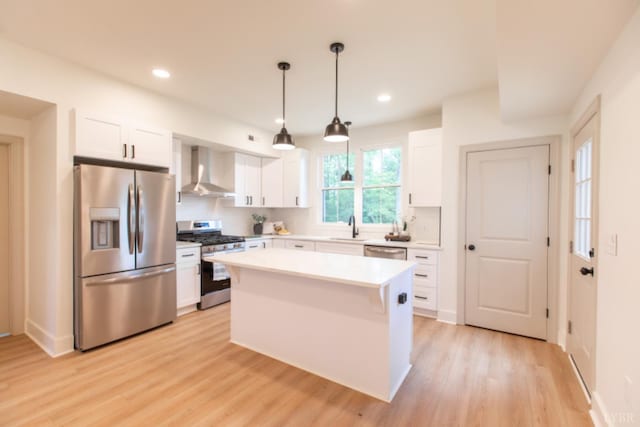 271 Riverside Dr, Lynchburg, VA 24503 - kitchen featuring appliances with stainless steel finishes, wall chimney range hood, white cabinetry, light wood-style floors, and light countertops