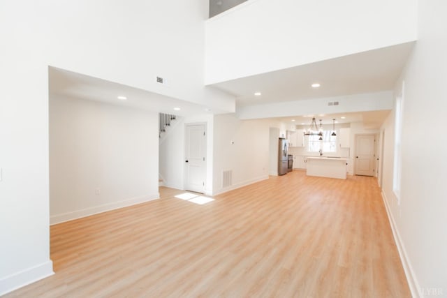 271 Riverside Dr, Lynchburg, VA 24503 - unfurnished living room with a chandelier, light wood-type flooring, recessed lighting, and stairs
