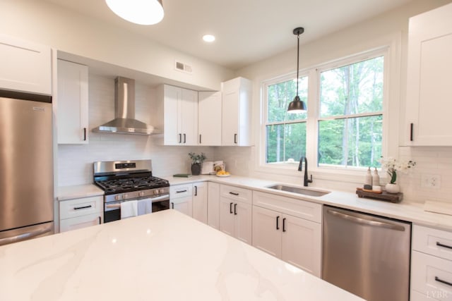 271 Riverside Dr, Lynchburg, VA 24503 - kitchen featuring appliances with stainless steel finishes, wall chimney range hood, decorative backsplash, white cabinets, and hanging light fixtures