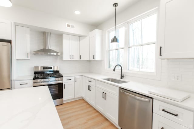 271 Riverside Dr, Lynchburg, VA 24503 - kitchen featuring stainless steel appliances, wall chimney range hood, tasteful backsplash, white cabinetry, and recessed lighting