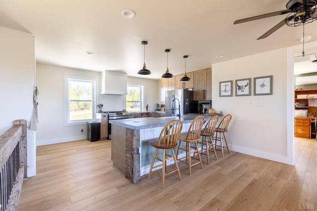 355 Camellia, Hurt, VA 24563 - kitchen with stainless steel appliances, a breakfast bar area, a ceiling fan, a peninsula, and baseboards
