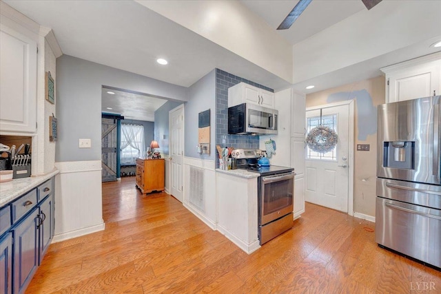 1014 Tall Tree Rd, Wirtz, VA 24184 - kitchen featuring stainless steel appliances, white cabinetry, light wood-type flooring, healthy amount of natural light, and wainscoting
