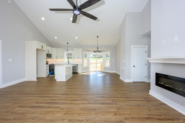 3936 Moorman Dr, Lynchburg, VA 24501 - unfurnished living room featuring high vaulted ceiling, a glass covered fireplace, ceiling fan, wood finished floors, and baseboards