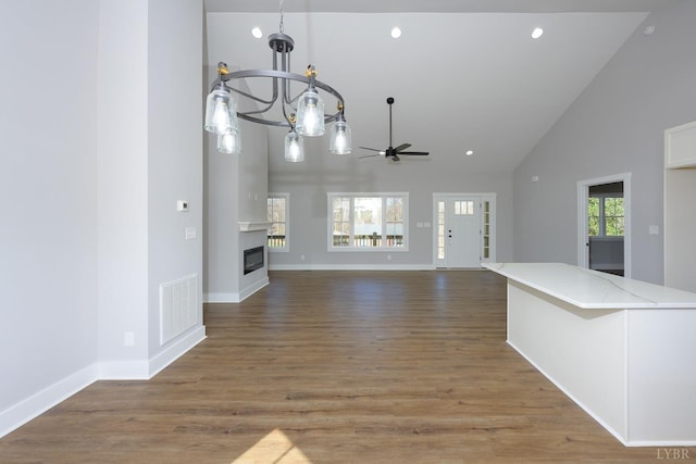 3936 Moorman Dr, Lynchburg, VA 24501 - unfurnished living room with ceiling fan, a chandelier, a glass covered fireplace, high vaulted ceiling, and baseboards