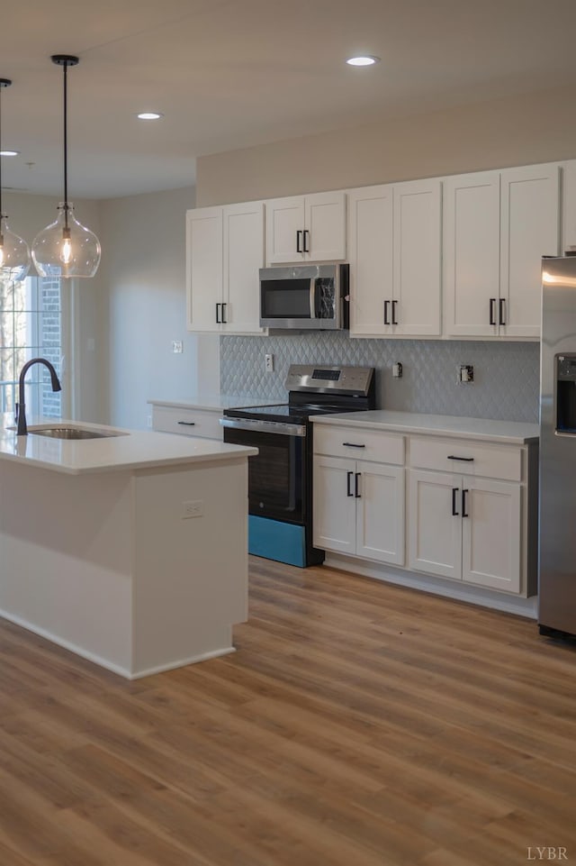 128 Brenleigh Ct Unit 102, Lynchburg, VA 24501 - kitchen with stainless steel appliances, a sink, light wood-style floors, white cabinetry, and backsplash