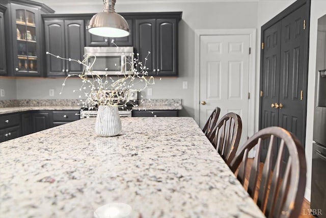 352 Wild Turkey Rd, Lynchburg, VA 24502 - kitchen with stainless steel microwave, glass insert cabinets, light stone countertops, and pendant lighting