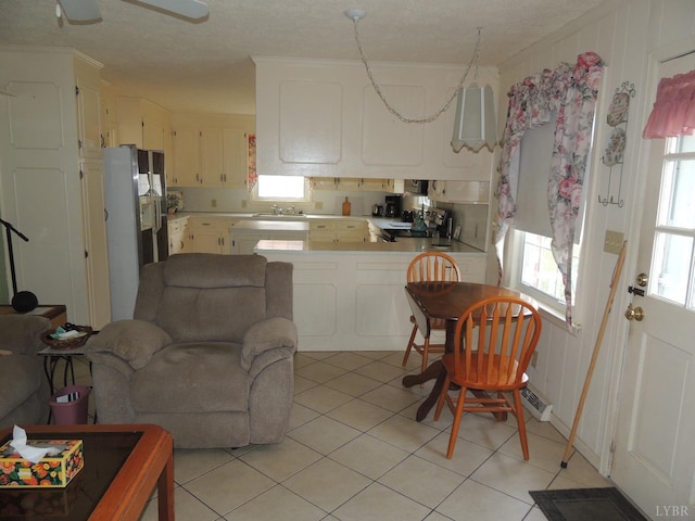 723 Custer Dr, Lynchburg, VA 24502 - kitchen with light countertops, white refrigerator with ice dispenser, a peninsula, light tile patterned floors, and electric range