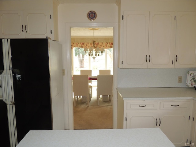 723 Custer Dr, Lynchburg, VA 24502 - kitchen featuring light countertops, a chandelier, carpet, white cabinetry, and freestanding refrigerator