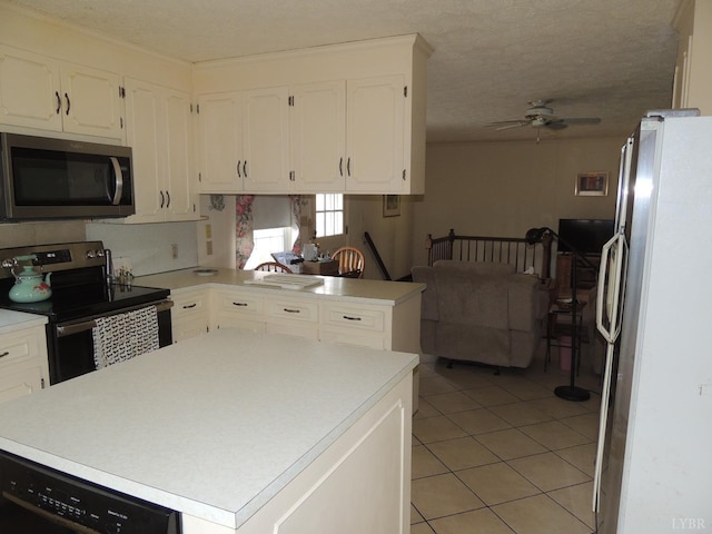 723 Custer Dr, Lynchburg, VA 24502 - kitchen featuring light tile patterned flooring, light countertops, a ceiling fan, appliances with stainless steel finishes, and white cabinetry