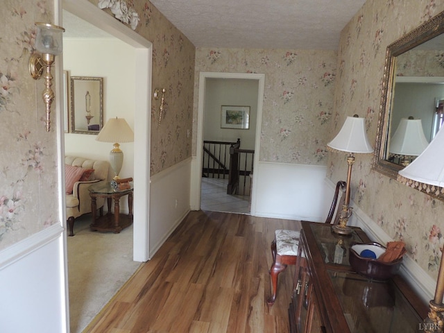 723 Custer Dr, Lynchburg, VA 24502 - hallway with a wainscoted wall, a textured ceiling, an upstairs landing, wallpapered walls, and wood finished floors