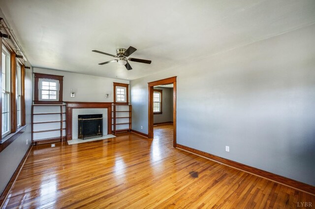 501 W Spencer Rd, Hurt, VA 24563 - unfurnished living room featuring baseboards, light wood-style flooring, ceiling fan, and a fireplace