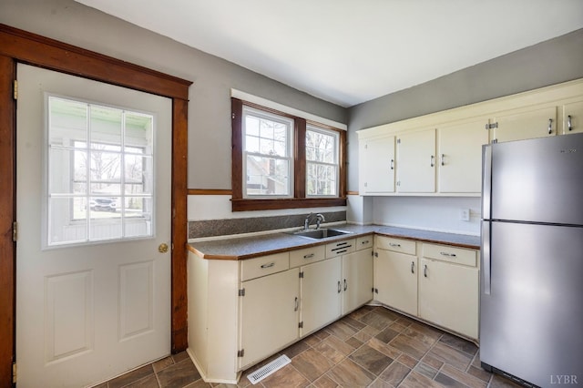 501 W Spencer Rd, Hurt, VA 24563 - kitchen with freestanding refrigerator, a sink, stone finish flooring, and cream cabinetry