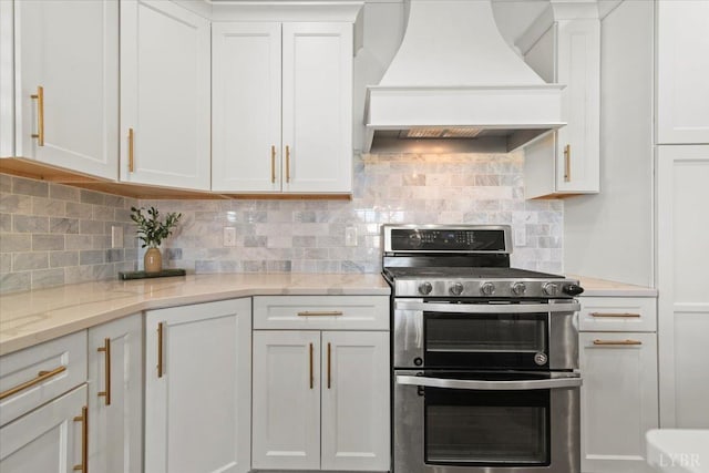 1031 Tori Ct, Forest, VA 24551 - kitchen with range with two ovens, wall chimney exhaust hood, white cabinetry, and tasteful backsplash