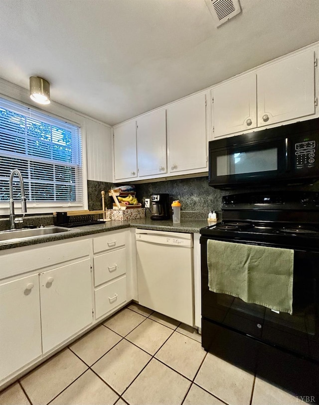 3101 Link Rd Unit 36, Lynchburg, VA 24503 - kitchen featuring black appliances, a sink, light tile patterned floors, dark countertops, and white cabinets