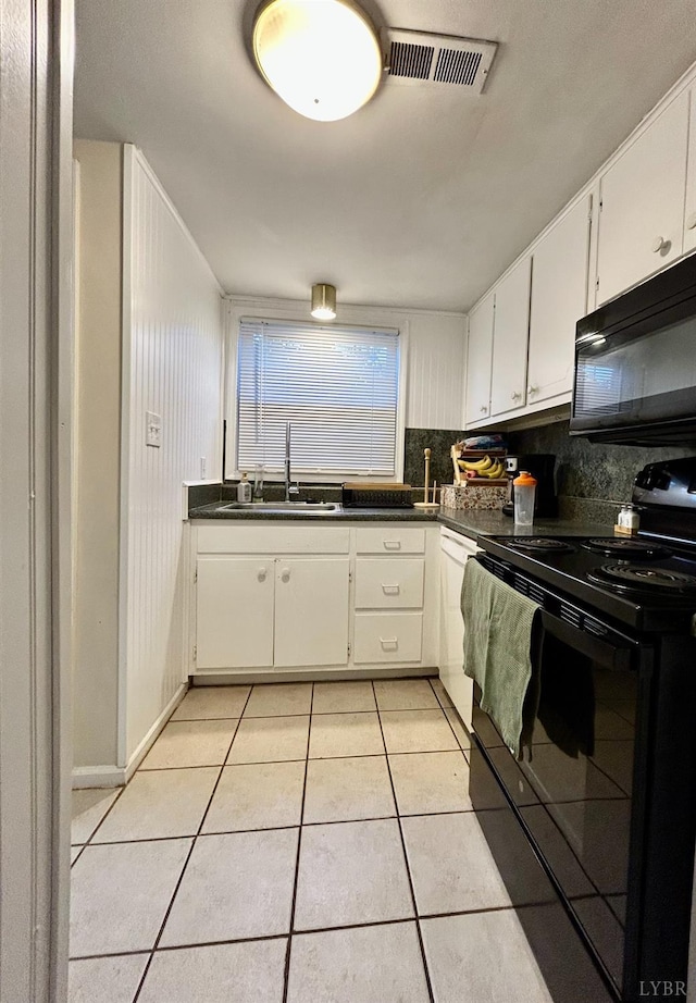 3101 Link Rd Unit 36, Lynchburg, VA 24503 - kitchen featuring black appliances, a sink, light tile patterned floors, dark countertops, and white cabinetry
