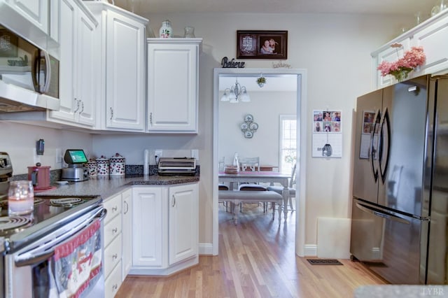 84 Jeter Ct, Lynchburg, VA 24501 - kitchen with appliances with stainless steel finishes, white cabinets, light wood-style floors, and dark countertops