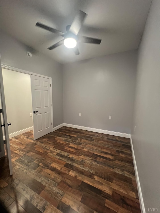 spare room with a ceiling fan, baseboards, and dark wood-style floors