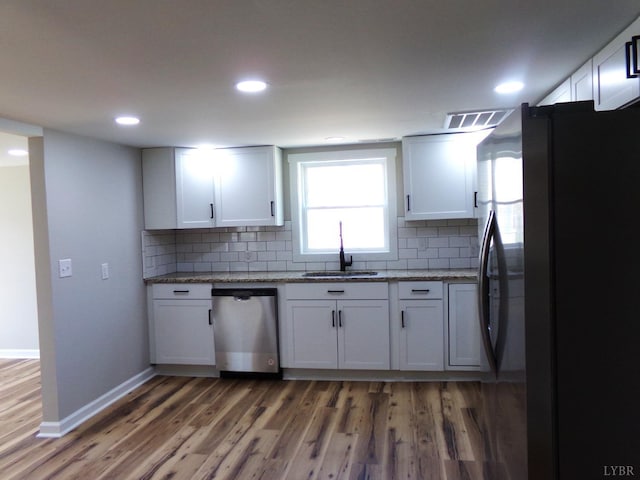1021 Bowman Ln, Bedford, VA 24523 - kitchen with stainless steel appliances, a sink, light wood-style flooring, backsplash, and white cabinetry