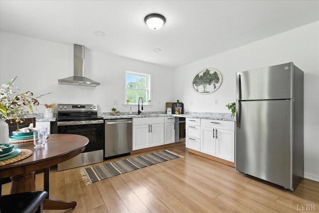109 Ned Brown Rd, Amherst, VA 24521 - kitchen featuring stainless steel appliances, wall chimney range hood, light stone countertops, white cabinetry, and light wood-type flooring