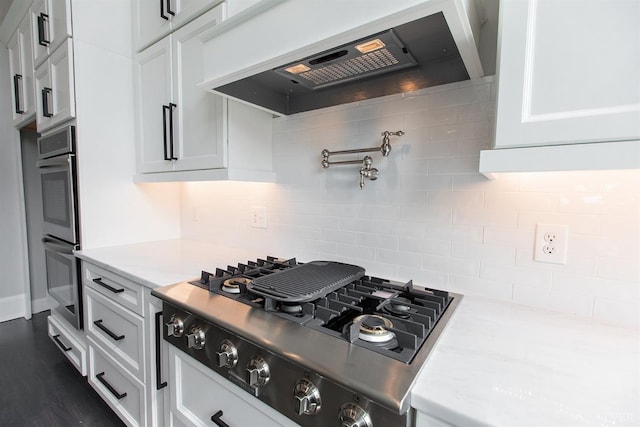 14 Deer Hollow Rd, Forest, VA 24551 - kitchen with wall chimney exhaust hood, stovetop with downdraft, light countertops, stainless steel double oven, and backsplash
