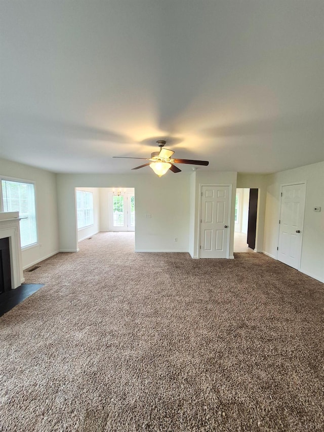 188 Oak Spring Ln, Madison Heights, VA 24572 - unfurnished living room with carpet, a ceiling fan, healthy amount of natural light, and a fireplace with flush hearth