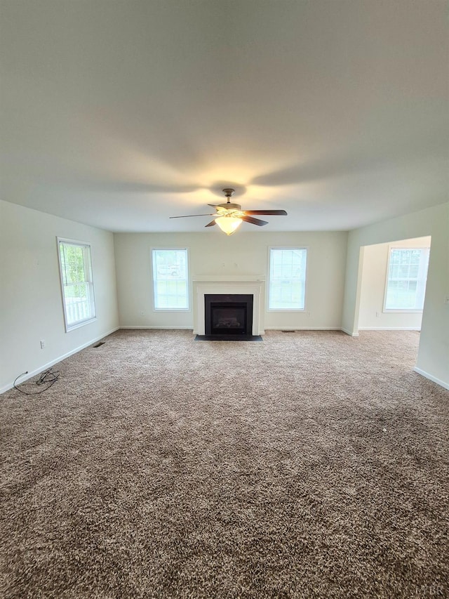 188 Oak Spring Ln, Madison Heights, VA 24572 - unfurnished living room with plenty of natural light, a fireplace with flush hearth, a ceiling fan, and carpet