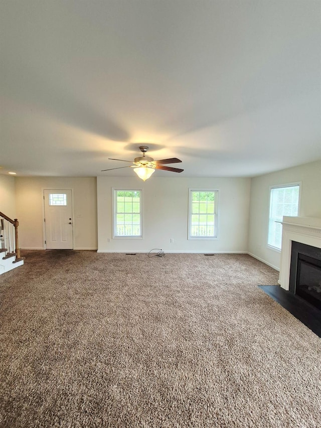 188 Oak Spring Ln, Madison Heights, VA 24572 - unfurnished living room featuring stairway, carpet flooring, a ceiling fan, and a fireplace with flush hearth