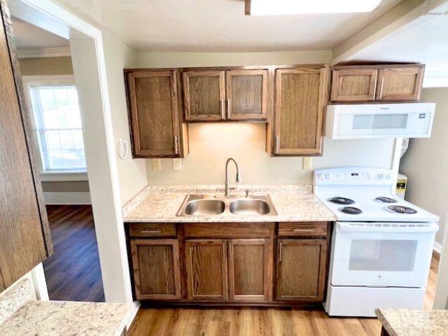 2024 Poplar St, Lynchburg, VA 24504 - kitchen featuring white appliances, light wood-style floors, and brown cabinetry