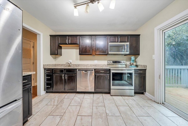 1048 Grove Ln, Roanoke, VA 24012 - kitchen with stainless steel appliances, dark brown cabinetry, light stone countertops, and a sink