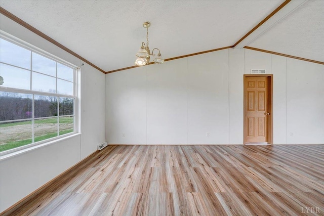 unfurnished room featuring visible vents, an inviting chandelier, ornamental molding, wood finished floors, and lofted ceiling